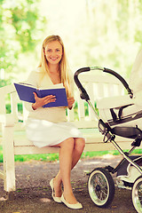 Image showing happy mother with book and stroller in park