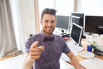 Image showing happy male office worker pointing finger at you