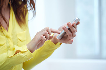 Image showing close up of female hands with smartphone at home