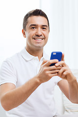 Image showing happy man with smartphone at home