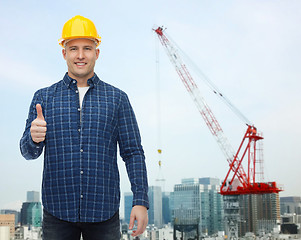 Image showing smiling male builder in helmet showing thumbs up