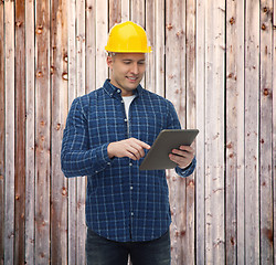 Image showing smiling male builder in helmet with tablet pc