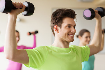 Image showing group of smiling people working out with dumbbells