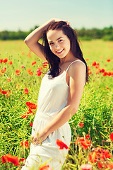 Image showing smiling young woman on poppy field