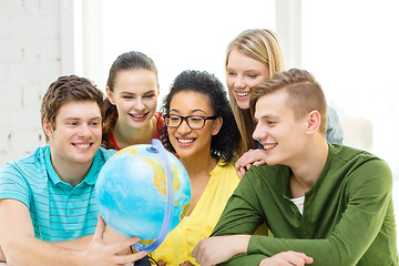 Image showing five smiling student looking at globe at school