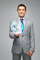 Image showing happy businessman in suit showing globe hologram