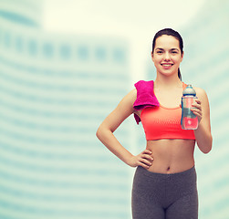 Image showing sporty woman with towel and water bottle