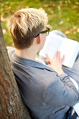 Image showing teenage boy or young man reading book outdoors