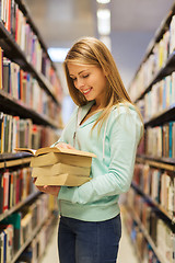 Image showing happy student girl or woman with book in library