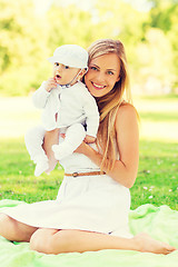 Image showing happy mother with little baby sitting on blanket