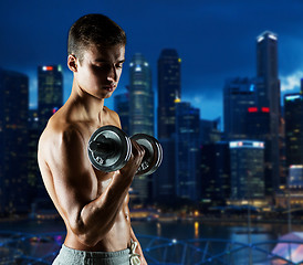 Image showing young man with dumbbell flexing biceps