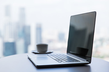 Image showing close up of laptop and coffee cup on office table