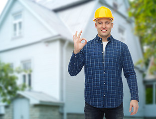 Image showing smiling male builder in helmet showing ok sign