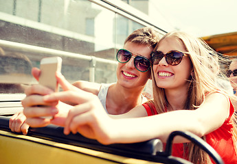 Image showing smiling couple with smartphone making selfie