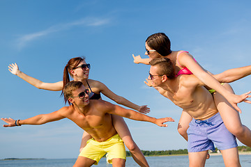 Image showing smiling friends having fun on summer beach
