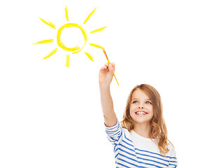 Image showing cute little girl drawing sun with brush