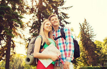 Image showing smiling couple with map and backpack in nature