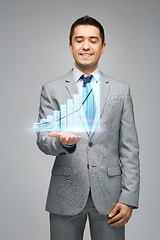 Image showing happy businessman showing virtual chart projection