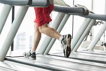 Image showing close up of male legs running on treadmill in gym