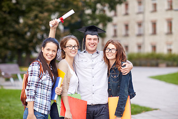 Image showing happy teenage students with diploma and folders