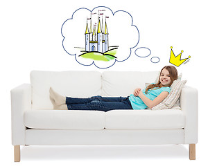 Image showing smiling little girl lying on sofa and dreaming