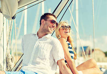 Image showing smiling couple sitting on yacht deck