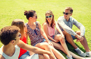 Image showing group of smiling friends outdoors sitting in park