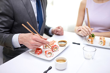 Image showing close up of couple eating sushi at restaurant