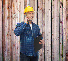 Image showing smiling male builder in helmet with clipboard