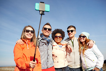 Image showing smiling friends taking selfie with smartphone