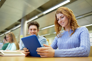 Image showing happy students with tablet pc in library