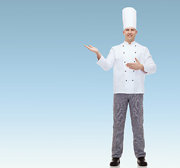 Image showing happy male chef cook inviting