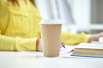 Image showing close up of female hands with books and coffee