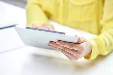 Image showing close up of female hands with tablet pc at table