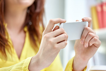 Image showing close up of female hands with smartphone at home