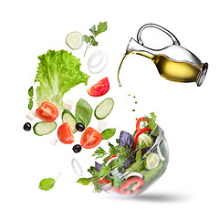 Image showing Falling vegetables for salad and oil isolated