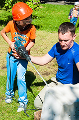 Image showing A child learns to work with electric drill