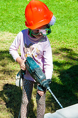 Image showing A child learns to work with electric drill