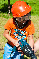 Image showing A child learns to work with electric drill