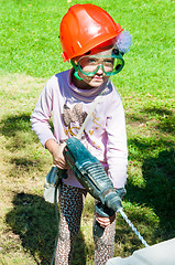 Image showing A child learns to work with electric drill