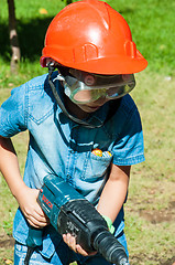 Image showing A child learns to work with electric drill