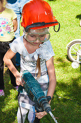 Image showing A child learns to work with electric drill