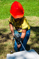 Image showing A child learns to work with electric drill