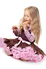 Image showing Girl in tutu skirt playing with party blower