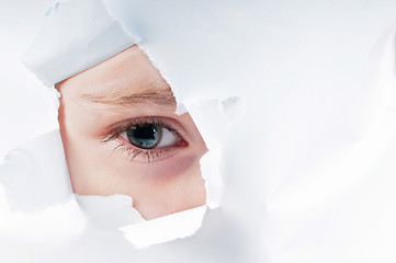 Image showing Cute baby girl looking through paper hole 