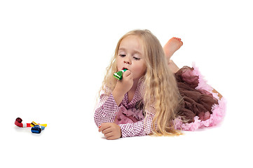 Image showing Little baby girl in tutu skirt using party blower