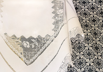 Image showing A white tablecloth with a lace pattern and an embroidered blanke