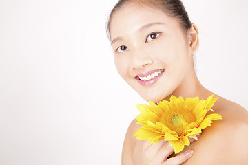 Image showing Beautiful young Asian girl with bright yellow sunflower