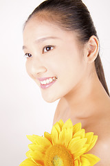 Image showing Beautiful young Asian girl with bright yellow sunflower