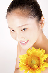 Image showing Beautiful young Asian girl with bright yellow sunflower